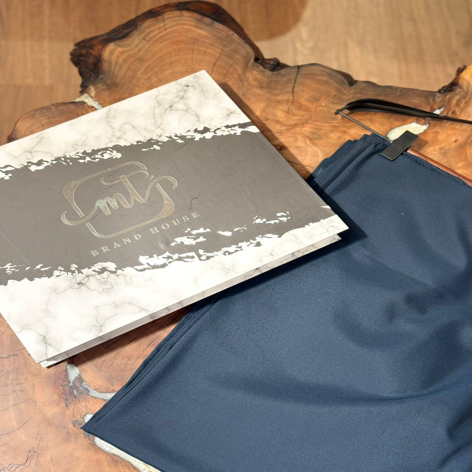 Blue fabric on a wooden surface with a branded box in the background