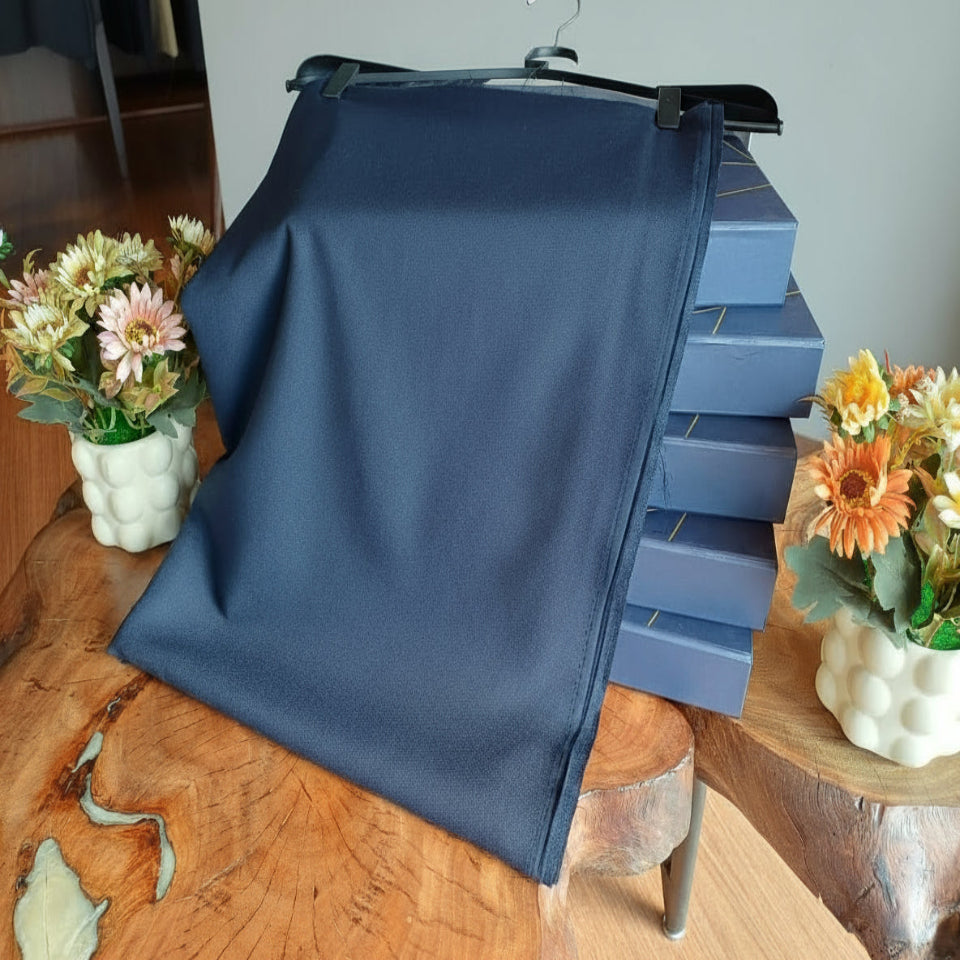 Blue fabric draped over a stack of blue boxes on a wooden table with floral decorations.
