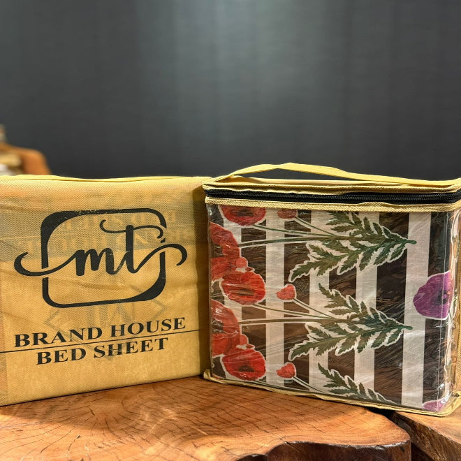 Packaged bed sheets with floral design on a wooden surface