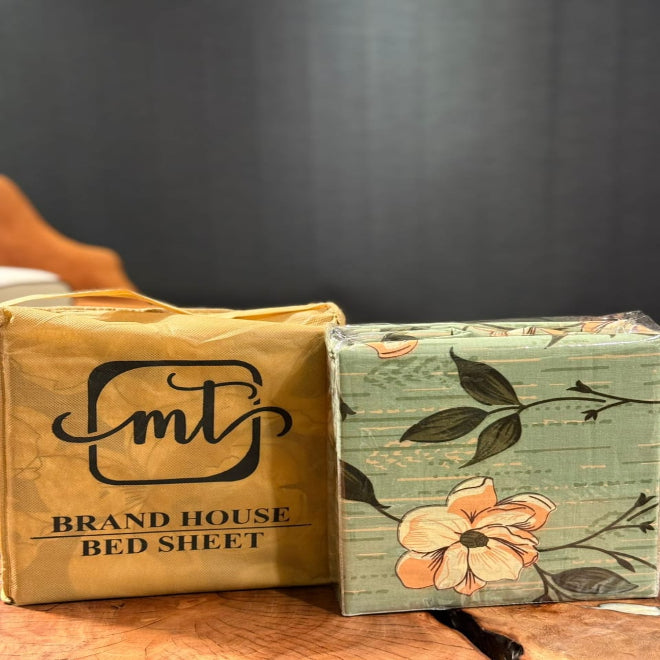 Packaged bed sheets with floral design on a wooden surface